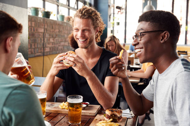 istock Three Young Male Friends Meeting For Drinks In Restaurant 1146671814