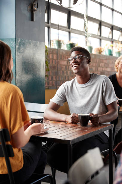 istock Couple Sitting At Table In Busy Coffee Shop Talking 1146672154