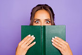 Close-up photo portrait of pretty sweet lovely smart clever cute wondered charming bookworm closing covering face with notebook notepad holding hands isolated violet background