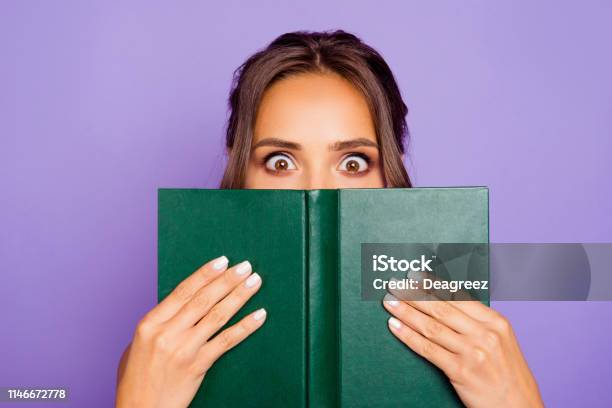 Closeup Photo Portrait Of Pretty Sweet Lovely Smart Clever Cute Wondered Charming Bookworm Closing Covering Face With Notebook Notepad Holding Hands Isolated Violet Background Stock Photo - Download Image Now