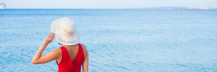 Woman walking on the beach on a sunny summer day.