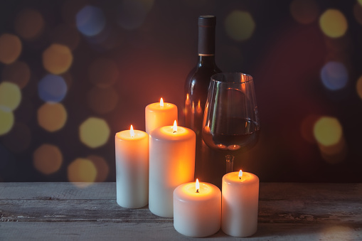Red wine with candles on dark background. View with copy space.