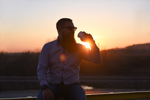 Businessman on a coffee break at sunset