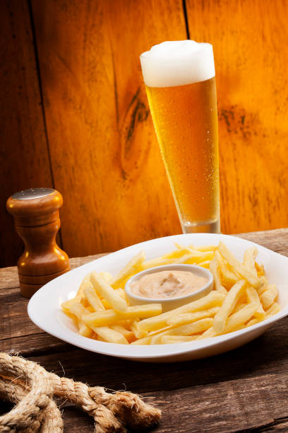 Salted chips with sauces and chopp on wood background