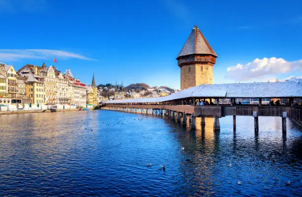 Lucerne, Switzerland, historical Old Town with wooden Chapel Bridge and Water Tower white snow covered in winter