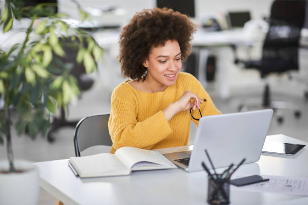 Busiensswoman looking at laptop while sitting in modern office. stock photo