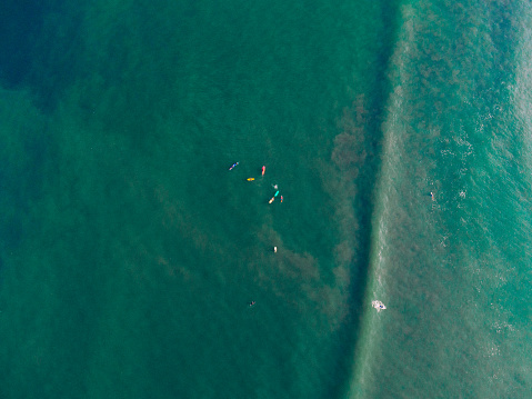 wave surfers in the ocean from above