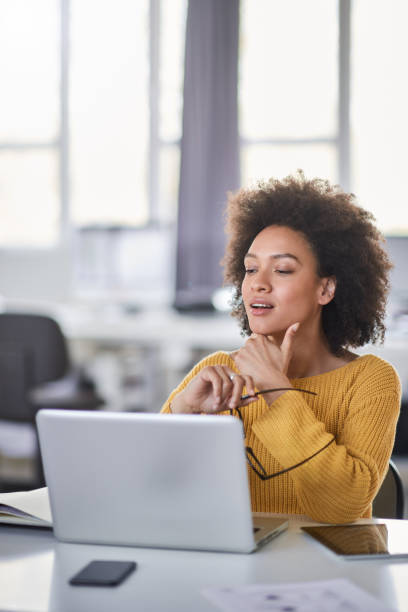 istock Businesswoman looking at laptop while sitting in office. 1146687072
