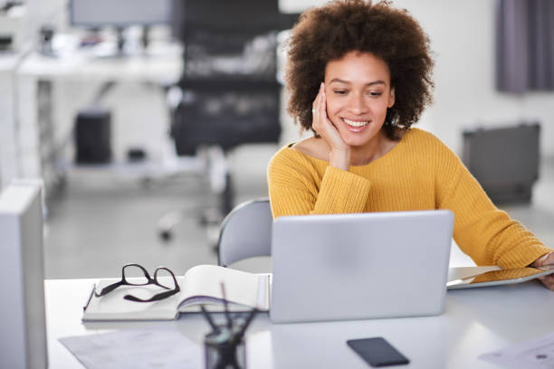 Businesswoman looking at laptop while sitting in office.