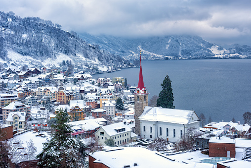 Weggis village on Lake Lucerne, swiss Alps mountains, Switzerland, covered with white snow in winter time