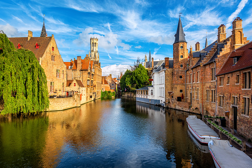 The Rozenhoedkaai canal, historical brick houses and the Belfry in Bruges medieval Old Town, Belgium, a UNESCO World Culture Heritage site