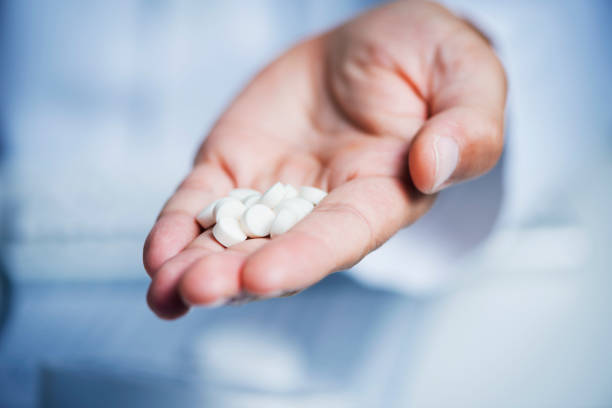 врач человек дает некоторые таблетки для наблюдателя - ibuprofen стоковые фото и изображения