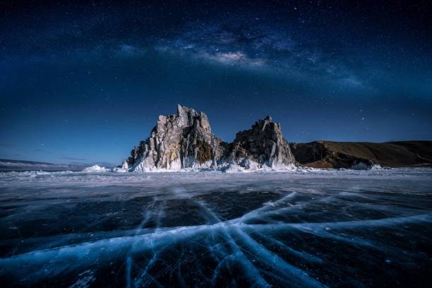 landschaft von schamanka felsen und milchstraße am himmel mit natürlichem brechen eis in gefrorenem wasser auf dem baikalsee, sibirien, russland. - baikalsee stock-fotos und bilder