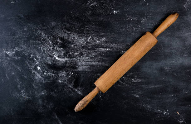 istock wooden rolling pin on a black background 1146700039
