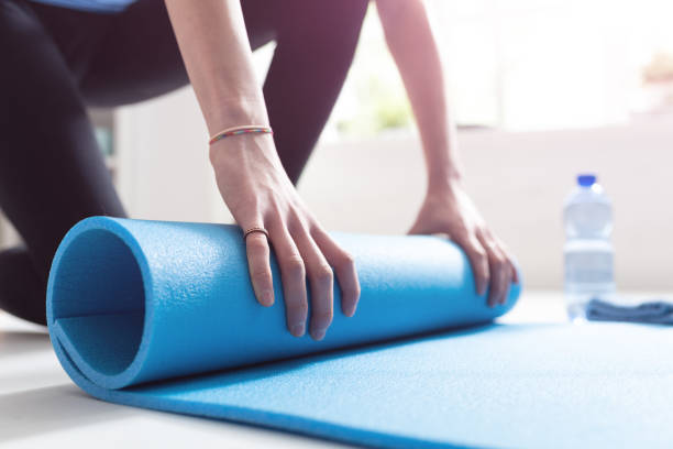istock Young woman rolling her mat after exercising, hands close up 1146701897
