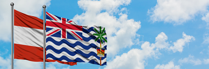Austria and British Indian Ocean Territory flag waving in the wind against white cloudy blue sky together. Diplomacy concept, international relations.