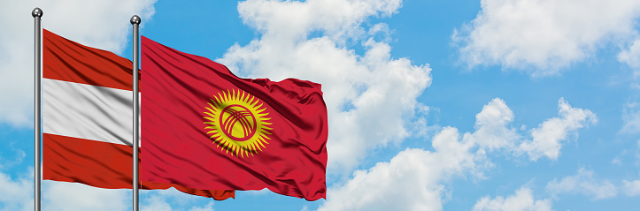 Austria and Kyrgyzstan flag waving in the wind against white cloudy blue sky together. Diplomacy concept, international relations.