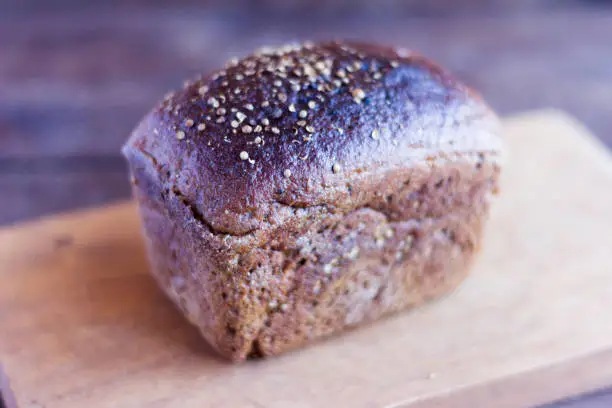 a loaf of rye Borodino bread on a wooden background