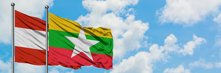 Austria and Myanmar flag waving in the wind against white cloudy blue sky together. Diplomacy concept, international relations.