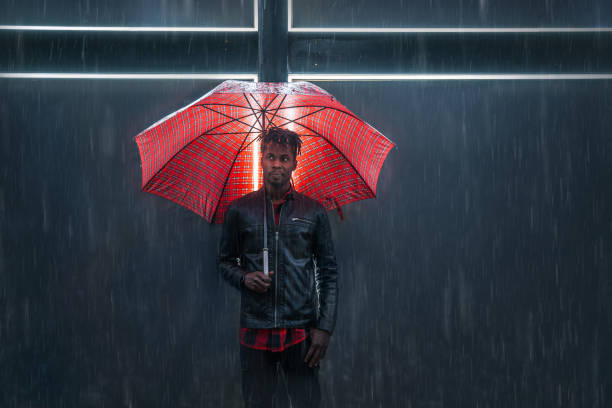 homem com o guarda-chuva vermelho a chuva - serious african ethnicity mid adult bright - fotografias e filmes do acervo