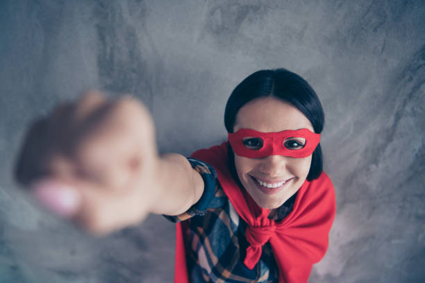 oben über dem hochwinkelblick nahaufnahme-porträt von ihr sie schön hübsch niedlich charmant geheimnisvolle fröhliche dame trägt helden-look outfit heben hand oben isoliert über graue betonwand - costume expressing positivity cheerful close up stock-fotos und bilder