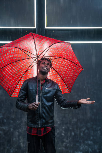 istock Man with red umbrella under rain 1146703758