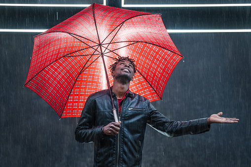 Man with red umbrella under rain