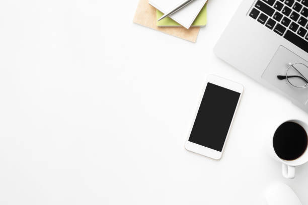 istock White office desk table with smartphone with blank mock up screen, laptop computer and supplies. Top view with copy space, flat lay. 1146704947