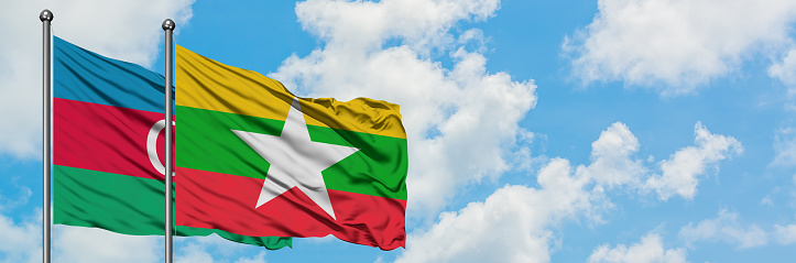 Azerbaijan and Myanmar flag waving in the wind against white cloudy blue sky together. Diplomacy concept, international relations.