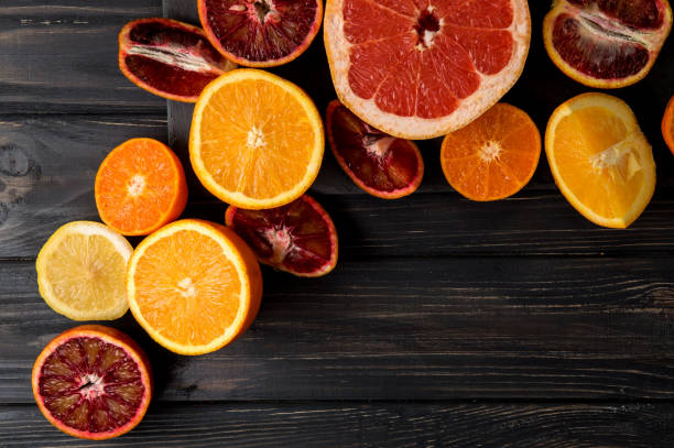 istock Top view, flat lay, macro. Sliced juicy oranges, tangerines, grapefruit. Dark background. Copy space. 1146705853