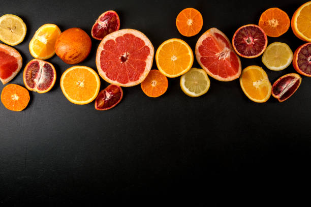 istock Flat lay, macro. Many slices bright citrus fruits on a black background. Copy space. 1146705884