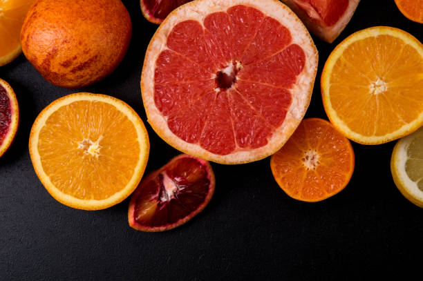 istock Top view, flat lay, macro. Sliced citrus fruits on a black background. 1146705953
