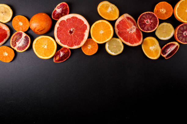 istock Top view, flat lay. Many slices citrus fruits on a black background. Copy space. 1146705975