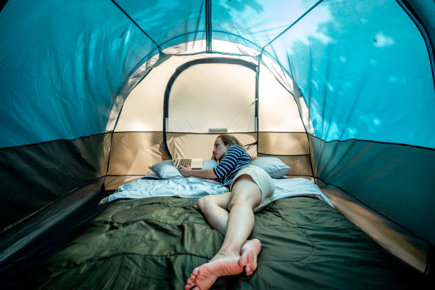 istock Woman working on a laptop inside a camping tent. 1146707736