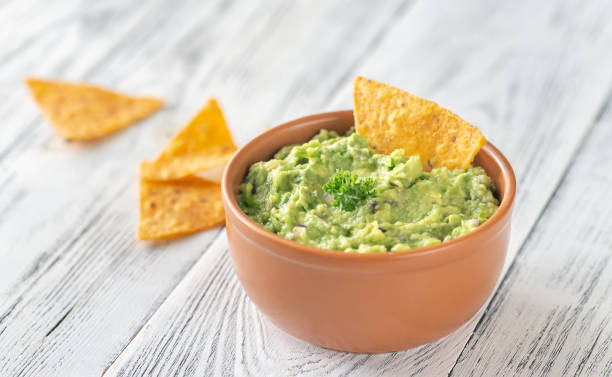 tazón de guacamole con chips de tortilla - guacamole fotografías e imágenes de stock