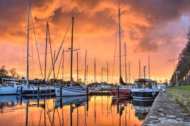Medemblik, The Netherlands, October 21, 2017: spectacular red skies over the Westerhaven marina as the setting sun illuminates a massive thunder cloud