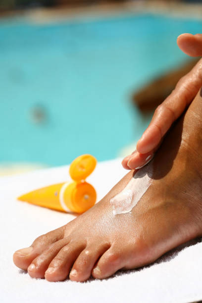 istock woman applying sunscreen on her feet 1146712391