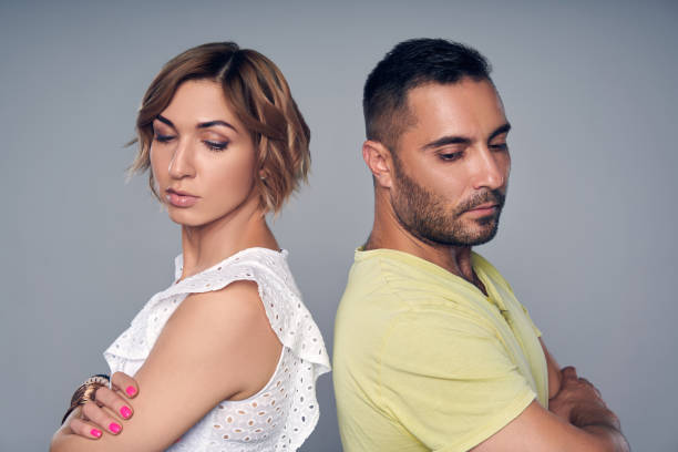 istock Young couple standing back to back with expression of sadness 1146716029