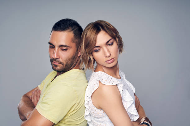 istock Young couple standing back to back with expression of sadness 1146717046