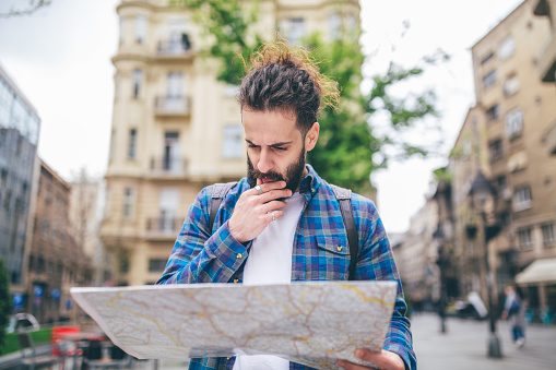 Man holding a map of the city, checking for directions and landmarks