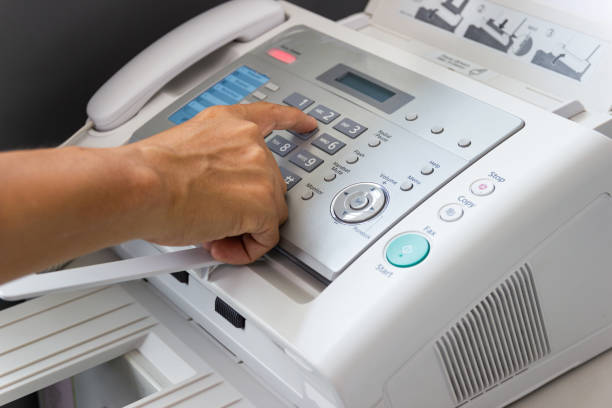 istock Hand man are using a fax machine in the office Business concept 1146722296