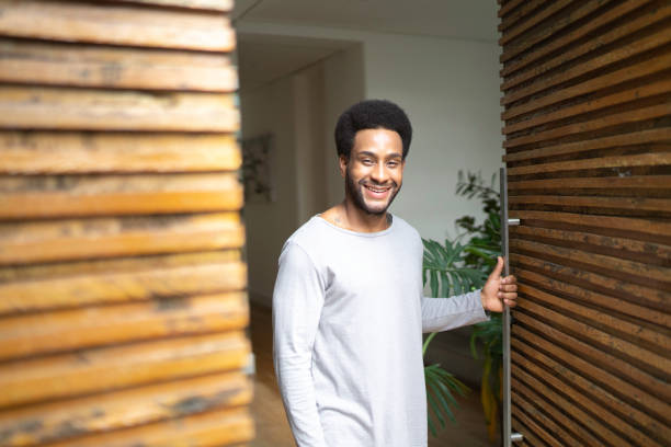 Man opening door, looking at camera - House Owner