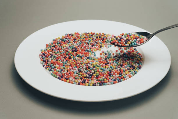 istock White plate with color preparations (vitamins, dyes, flavor enhancers, nutritional supplements, innovative technologies, candy sweets) on a gray background. 1146724031