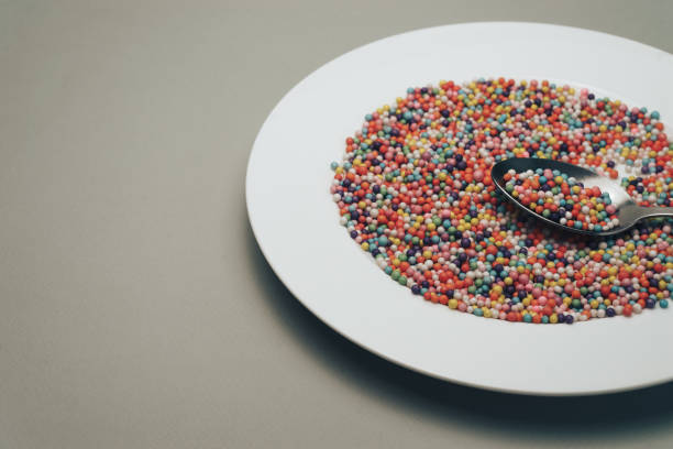 istock White plate with color preparations (vitamins, dyes, flavor enhancers, nutritional supplements, innovative technologies, candy sweets) on a gray background. 1146724271