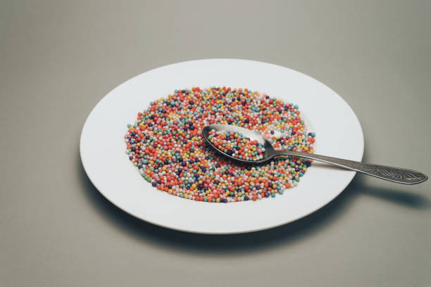 istock White plate with color preparations (vitamins, dyes, flavor enhancers, nutritional supplements, innovative technologies, candy sweets) on a gray background. 1146724447