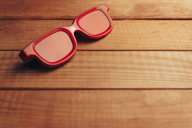 istock Red glasses on a brown wooden table background. Summer concept. 1146724547