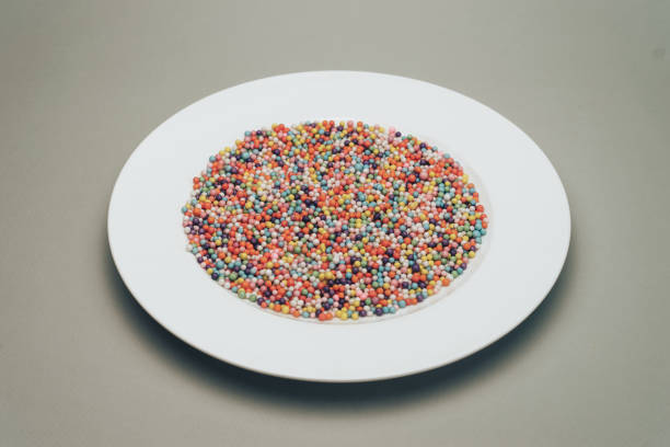 istock White plate with color preparations (vitamins, dyes, flavor enhancers, nutritional supplements, innovative technologies, candy sweets) on a gray background. 1146724554