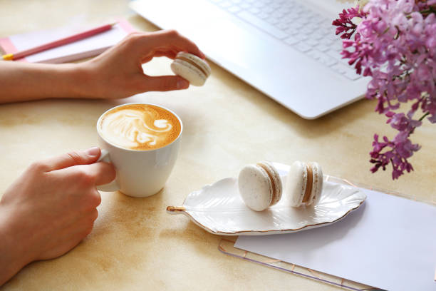 istock Female hands over textured table with flowers and electronic devices. 1146725357