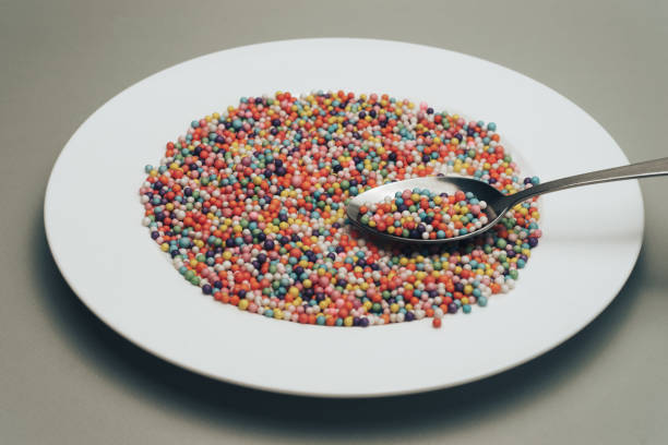 istock White plate with color preparations (vitamins, dyes, flavor enhancers, nutritional supplements, innovative technologies, candy sweets) on a gray background. 1146725400