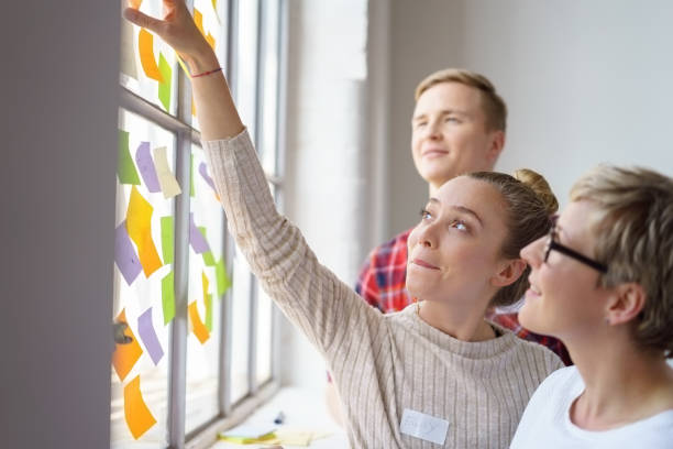 istock Woman placing sticky note high up on window 1146725747